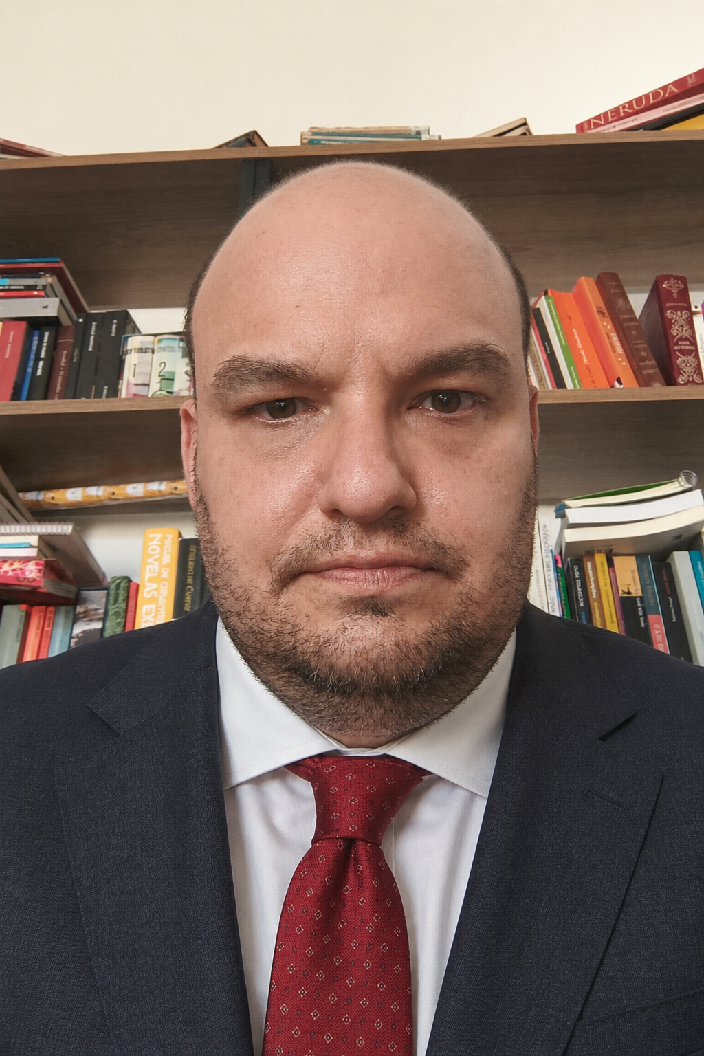 Retrato de Octávio Sandoval Morandini, advogado, em frente a uma estante de livros
